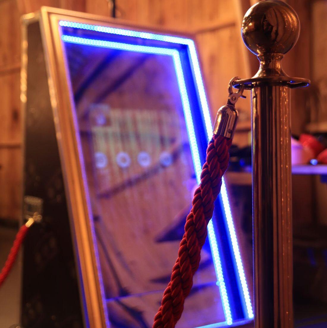 Fotospiegel mit blauer LED-Beleuchtung und Absperrkordel bei einer Veranstaltung