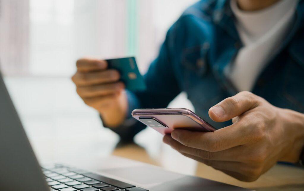 preisverhandlung beim onlinekauf mit smartphone kreditkarte und laptop auf schreibtisch