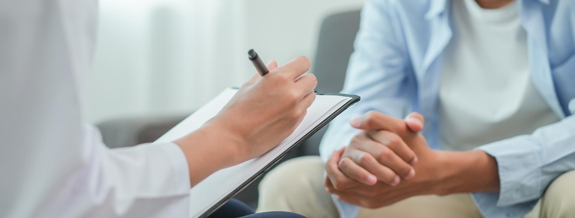 Arzt führt Gespräch mit Patient und notiert Befunde | Radiologie Frankfurt